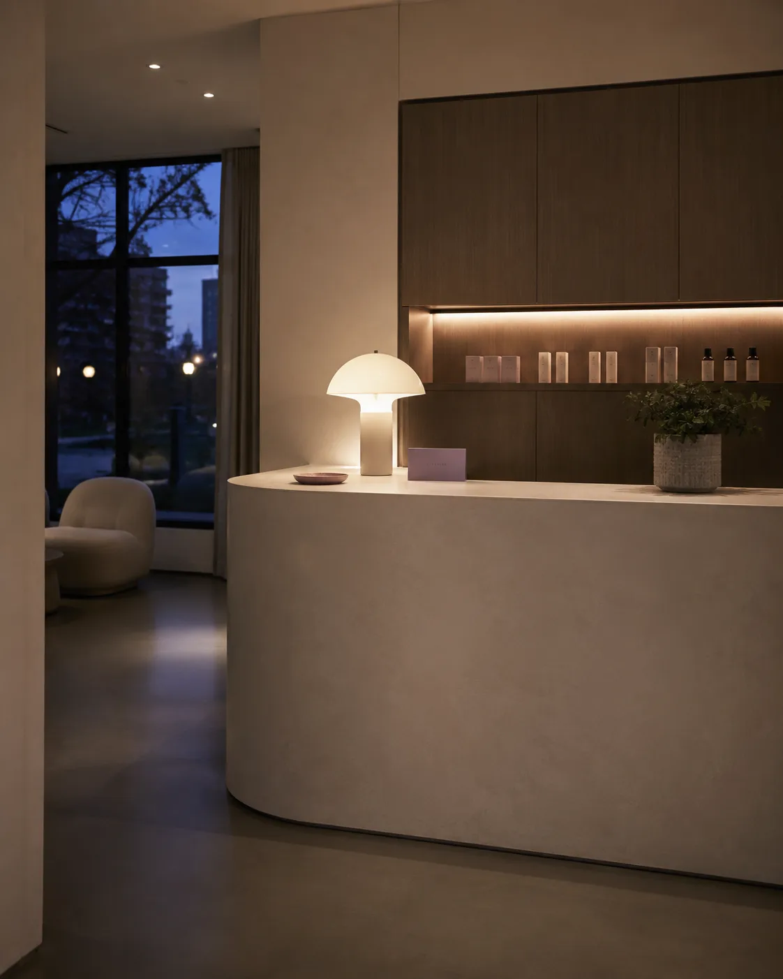 An empty reception counter at dusk, one lamp still glowing after closing time.